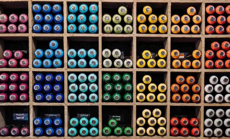 Spray paint cans organized into segments to represent supplier segmentation in category management.