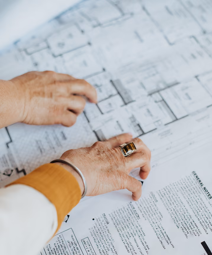 Hands reviewing architectural floor plans