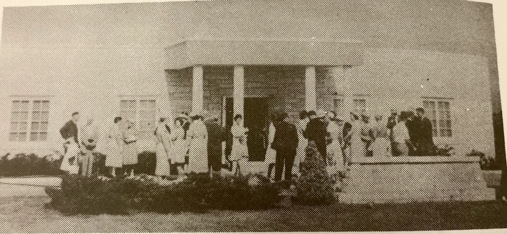 Vintage photo of worshippers gathering outside the early mission church entrance.
