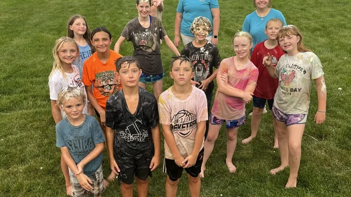 Group of kids covered in shaving cream and color after messy outdoor games at youth group.