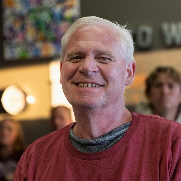Smiling senior man enjoys a church fellowship gathering.