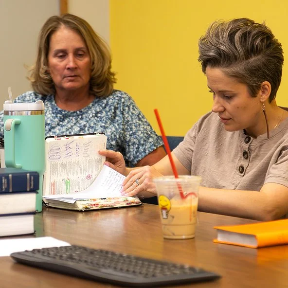 Two women study an annotated Bible together during a women's small group.