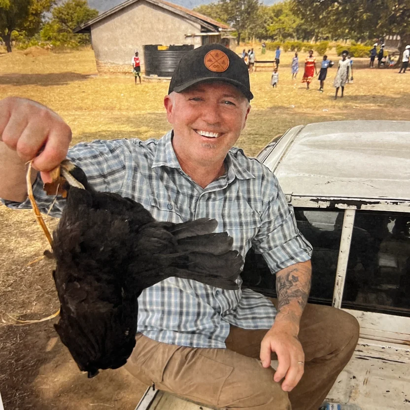 Smiling man with a bird outdoor.