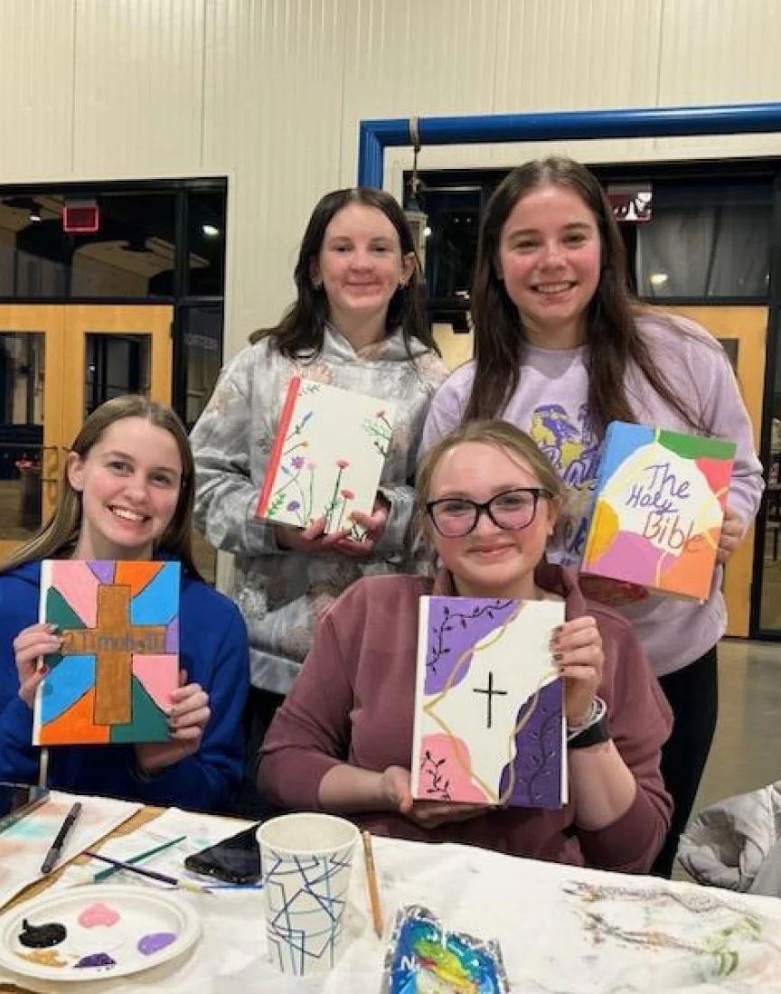 Four girls showing their artwork about the church.