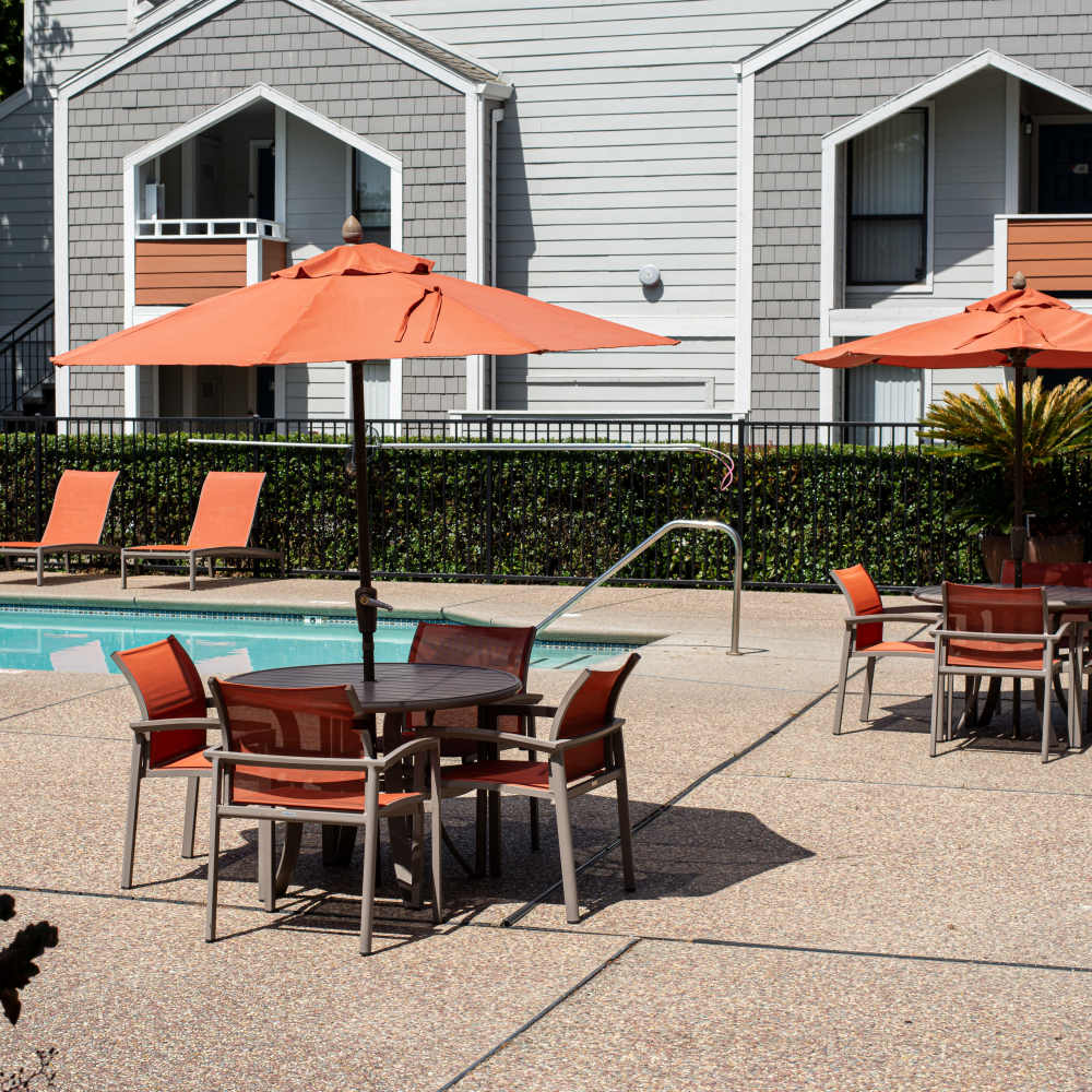 Swimming Pool with lounge chairs and tables with umbrellas
