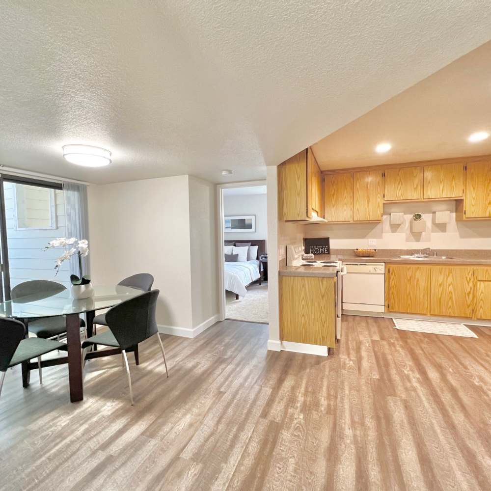 Wide view of dining area with table and chairs and kitchen