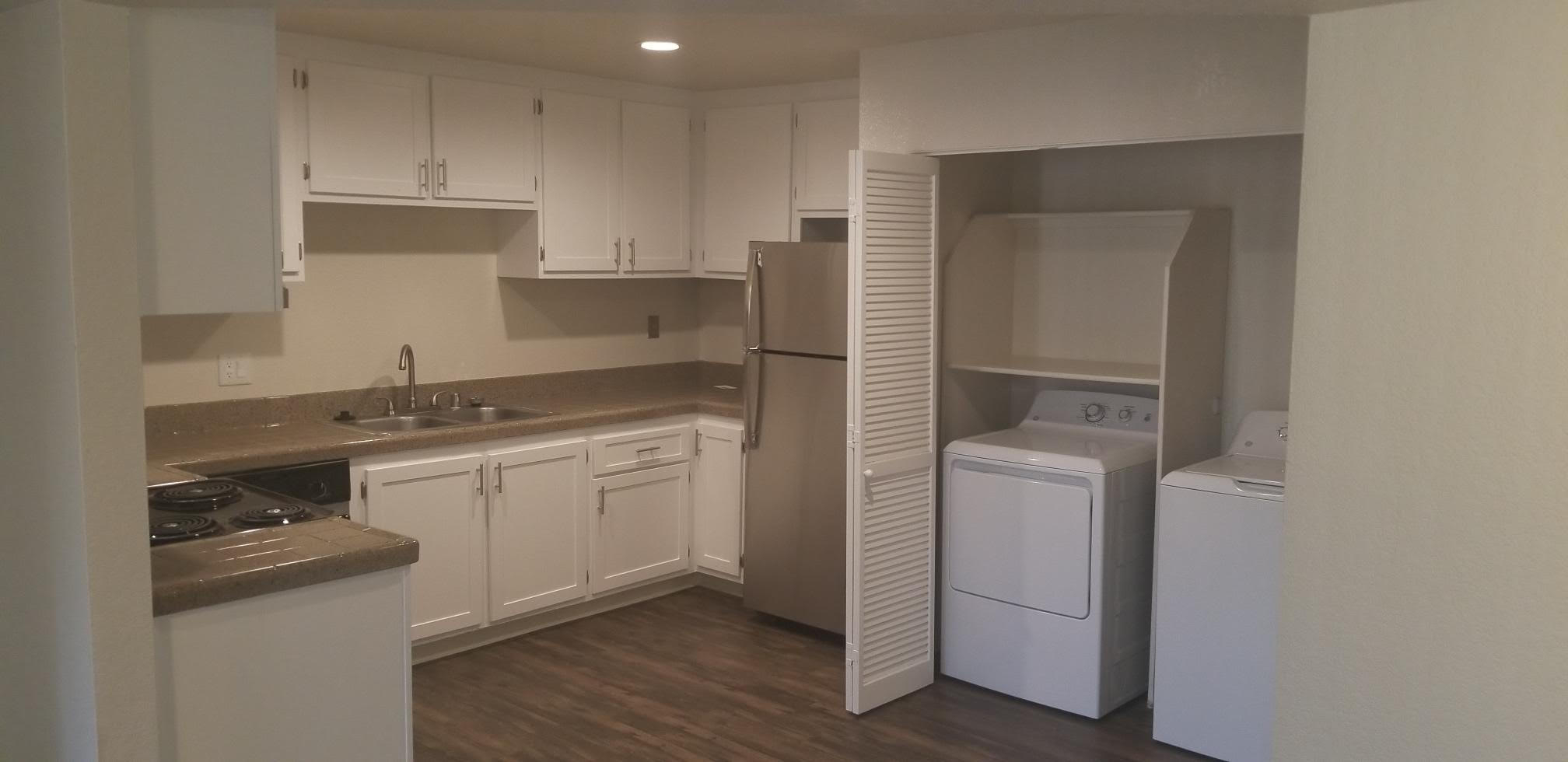 Kitchen with white cabinets and stainless steel appliances with view of laundry room