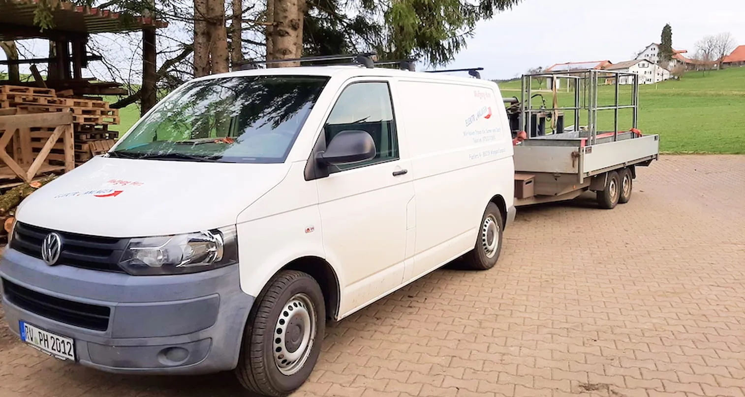 Servicefahrzeug von Elektroanlagen Herz mit Anhänger vor dem Firmengelände.