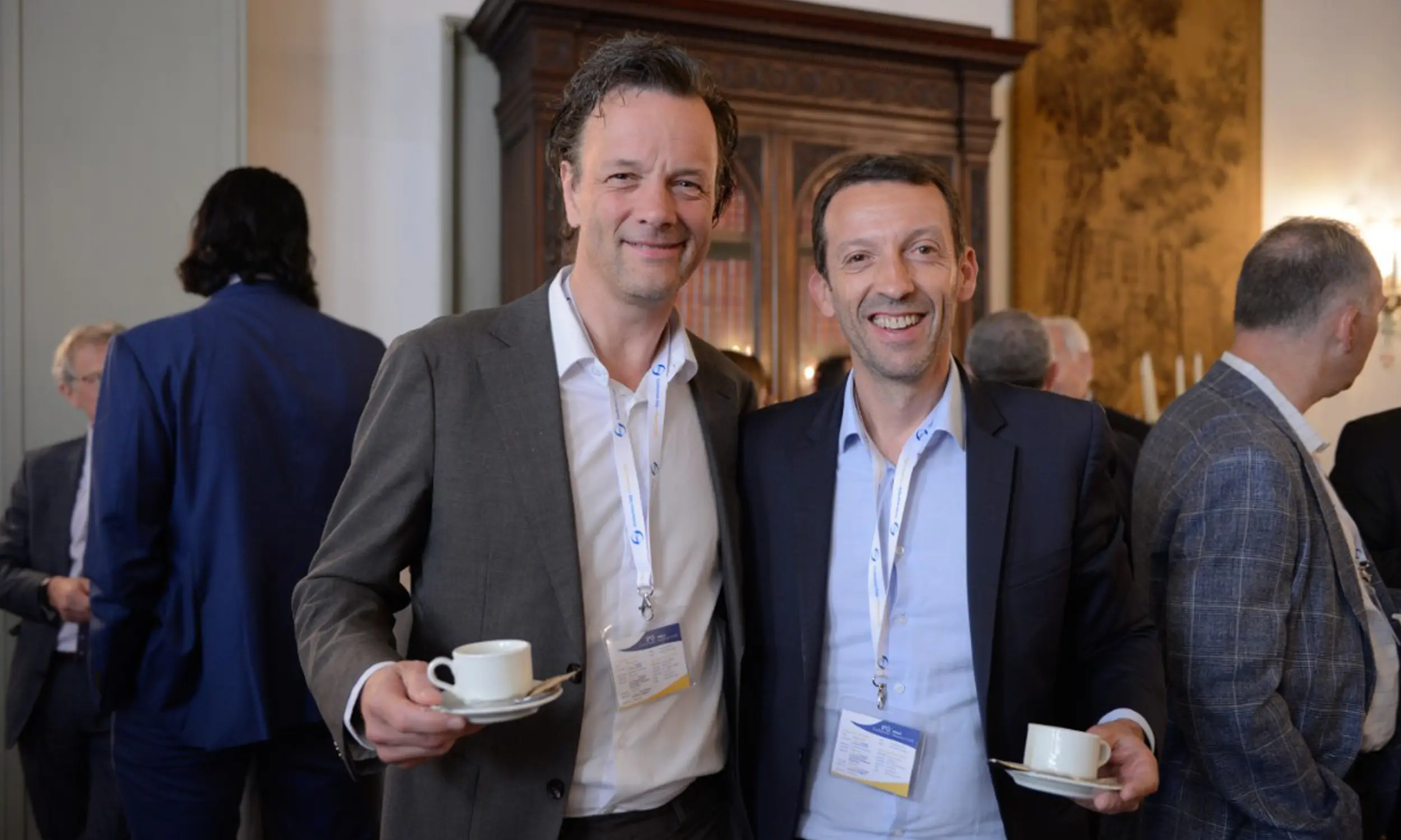 Two IPG members smiling over coffee during a conference break
