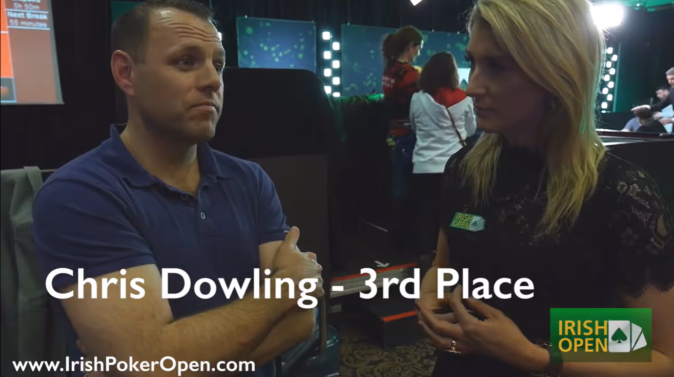 Man identified as Chris Dowling stands with arms crossed, talking to a blonde woman at Irish Poker Open.