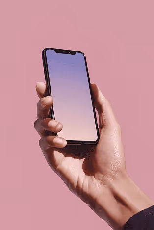 Hand holding a smartphone with a blank gradient screen against a pink background.