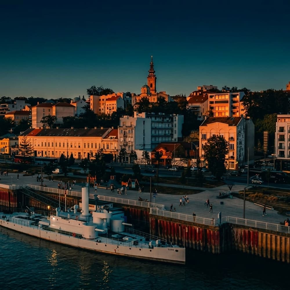 Belgrade riverside at dusk, boats moored below the old town