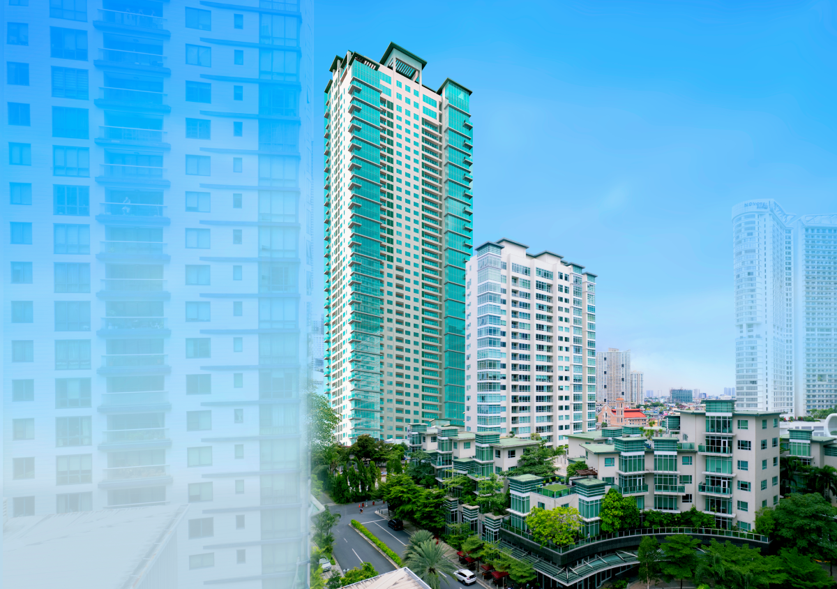 Modern high-rise buildings with glass balconies surrounded by greenery on a clear blue sky day.