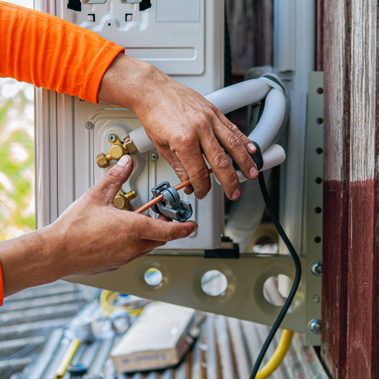 Un expert travaillant sur un moteur extérieur de climatisation
