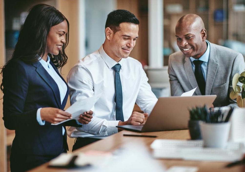 Three professionals going over notes before an important meeting.