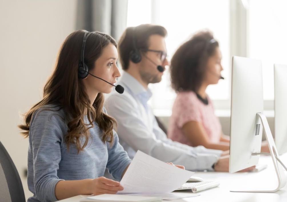 Three insurance reps on the phone with customers.