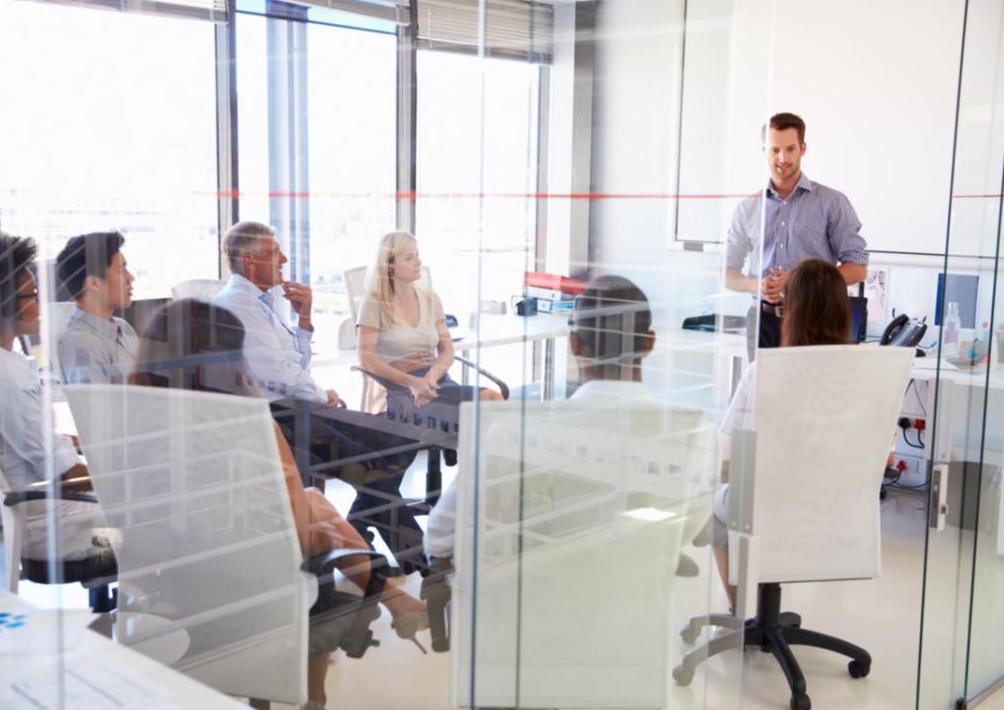 Several people are gathered in a meeting room.