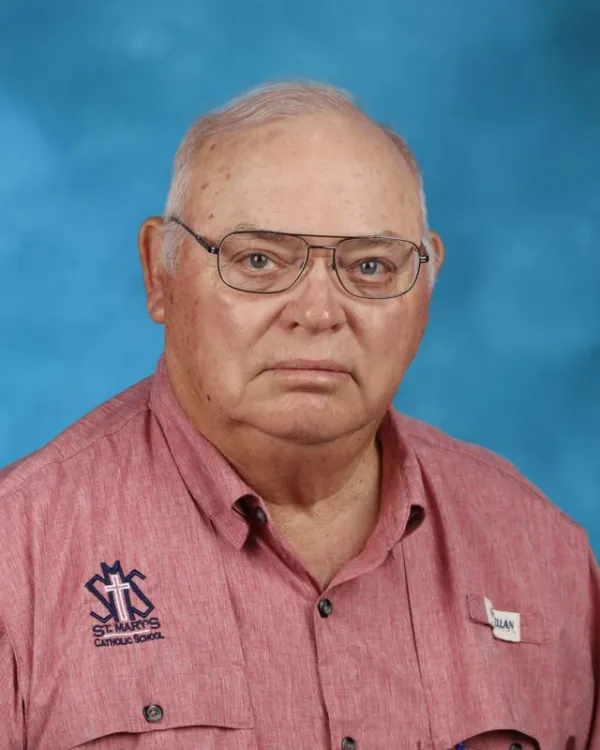 Staff portrait of Allan wearing a St. Mary's Catholic School shirt