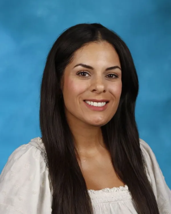 Staff portrait of Rosie Candeleria smiling against blue background
