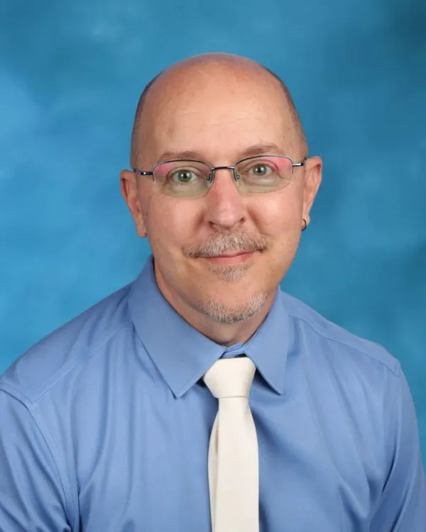 Staff portrait of David Cason wearing glasses and white tie