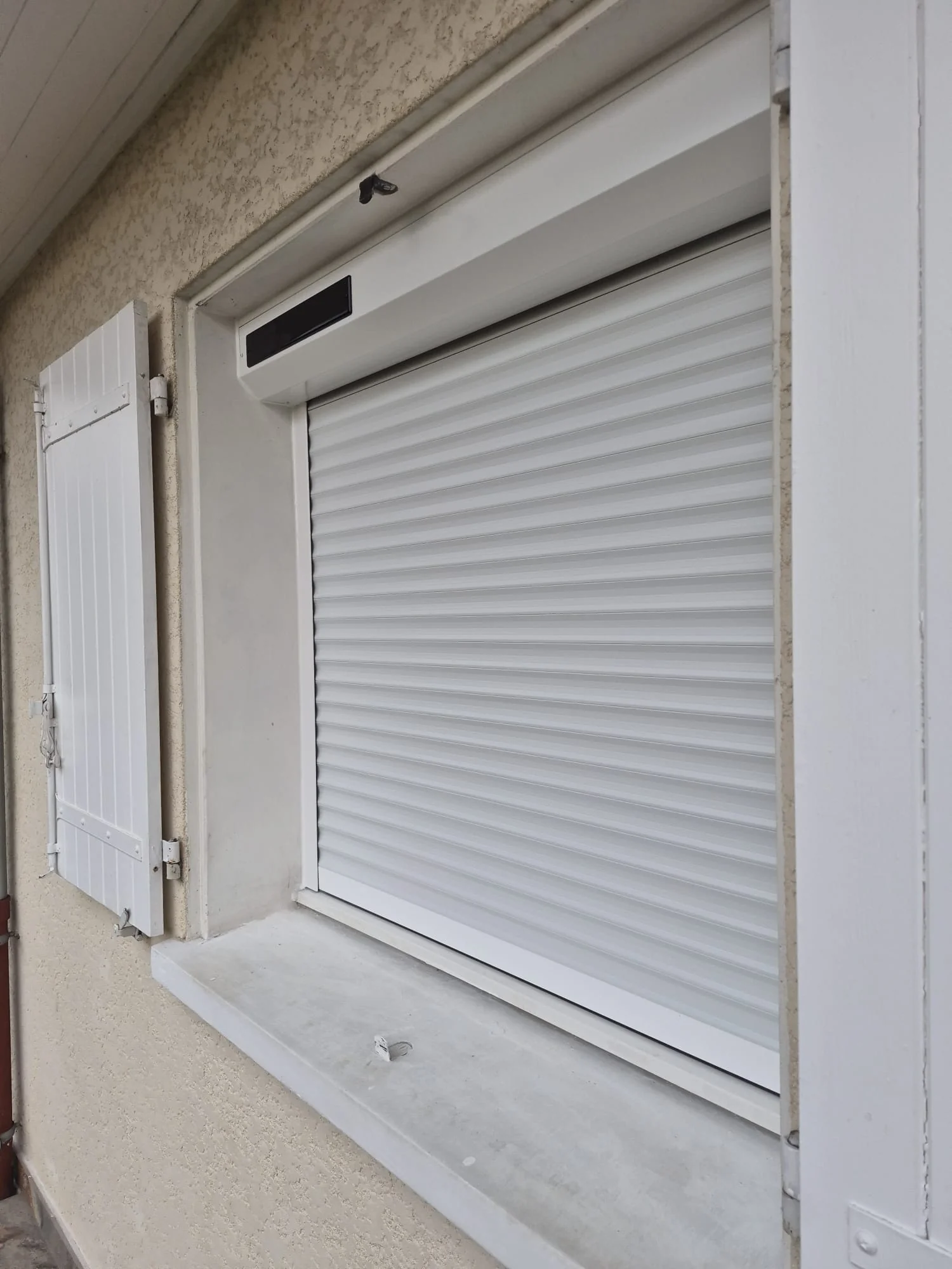 Volet roulant solaire posé en rénovation à Cranves-Sales, coffre avec panneau solaire Somfy io