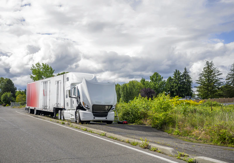 Mobile heavy-duty roadside service on a semi-truck with the hood raised for engine repair.