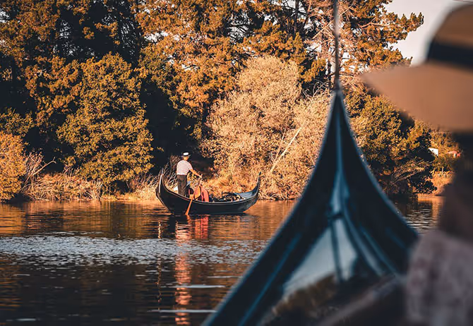 Venetian gondola gliding down the Napa River with a gondolier