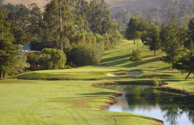 Sloping tree-lined fairway at Blue Rock Springs Golf Course West