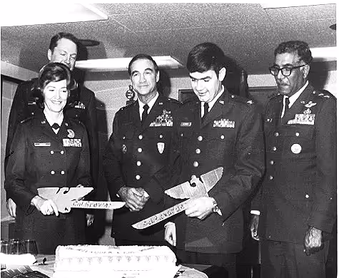 Husband and wife Air Force colonels cutting a cake with ceremonial swords