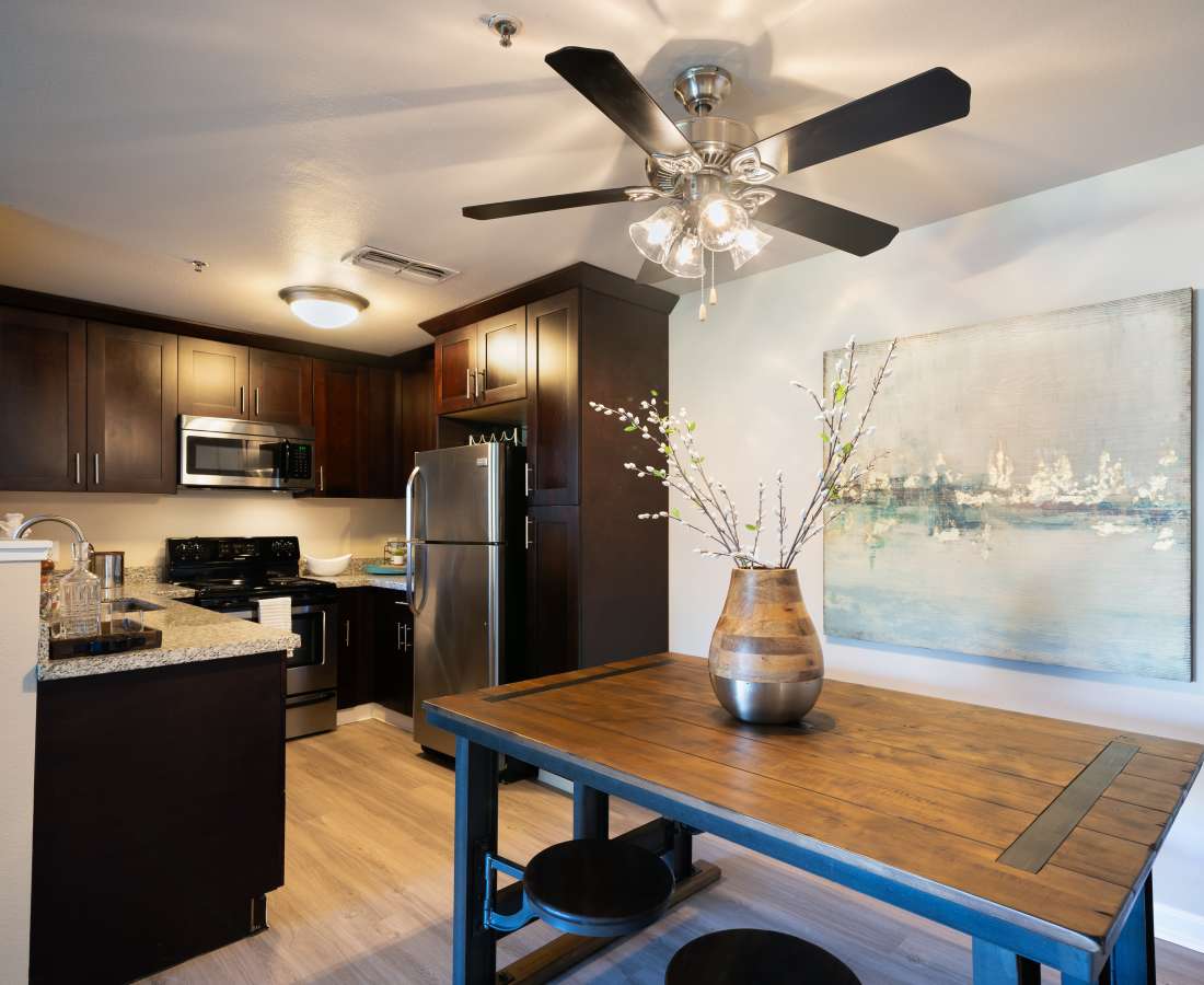Dining area with table and chairs and Kitchen with brown cabinets and stainless steel appliances