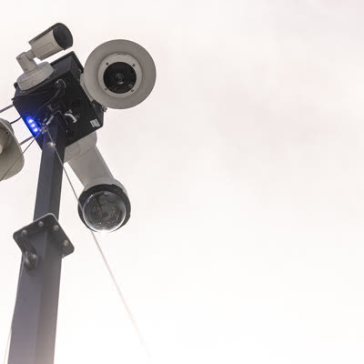 A camera head on its mast, seen from a low angle.