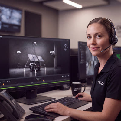A Deploy representative at a monitoring desk wearing a headset.