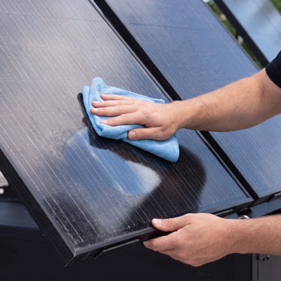 A technician cleaning a solar panel.