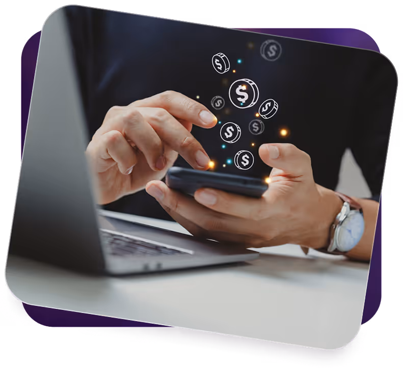 Person using smartphone with digital dollar icons floating above, next to an open laptop.