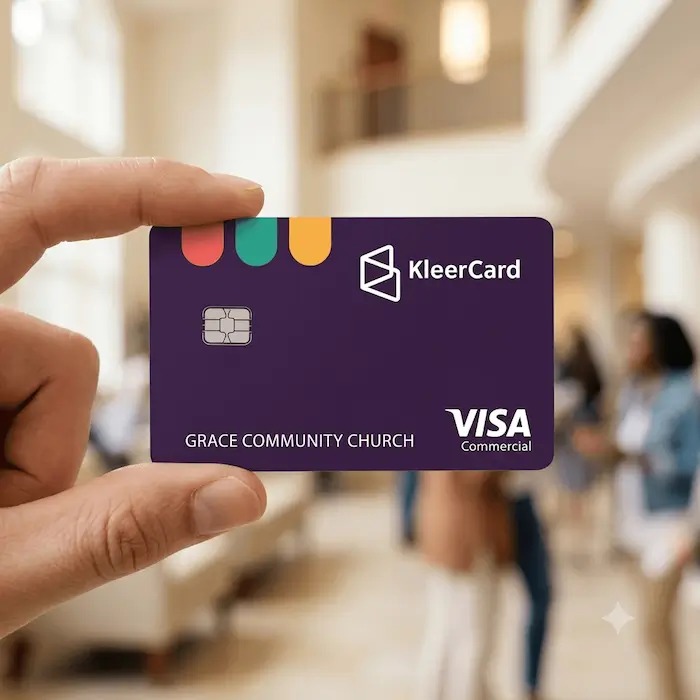 Hand holding a purple KleerCard Visa Commercial card with Grace Community Church name.