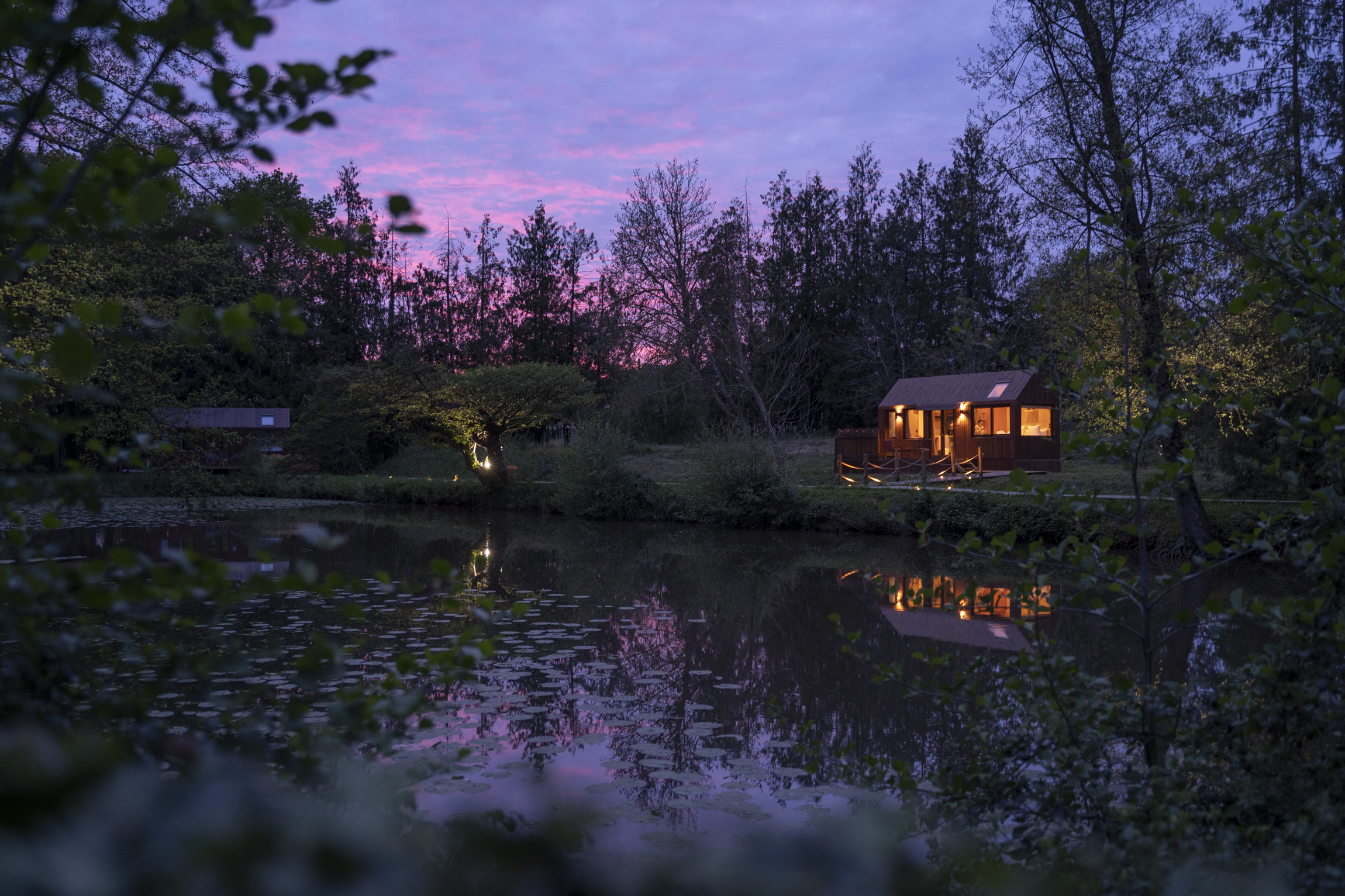 Lodge PAMPA illuminé au crépuscule au bord de l'étang d'Étival-lès-le-Mans