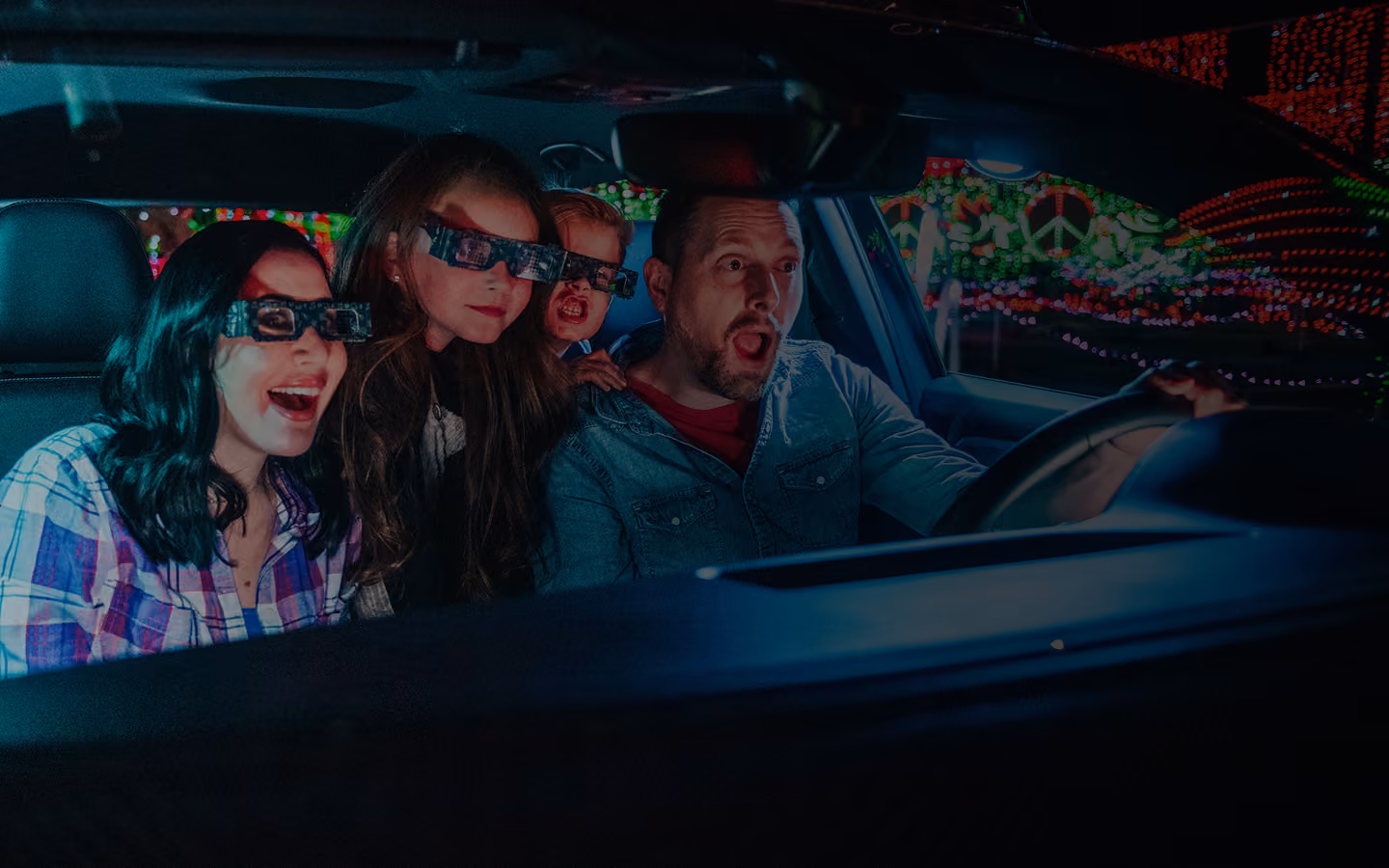 Four guests wearing 3D glasses watching the light show from their car