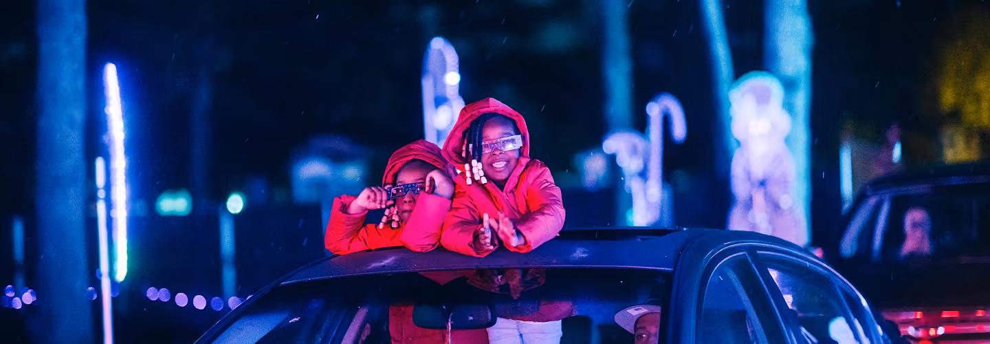 Guest in a red coat standing through the sunroof under the lights