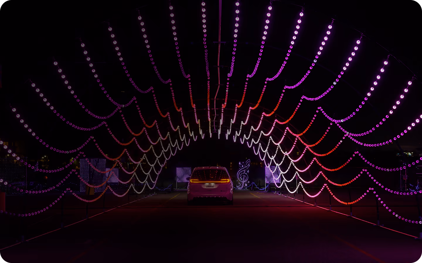 Car driving through a purple light tunnel