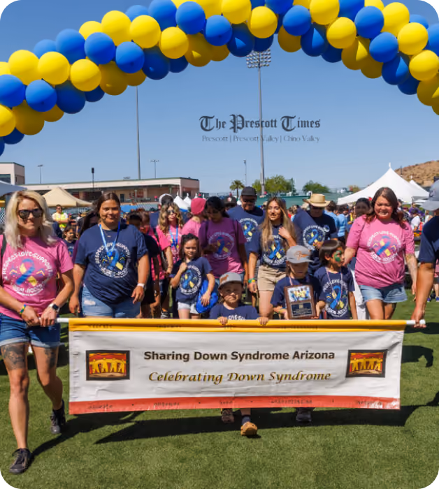 Sharing Down Syndrome Arizona team under a balloon arch at their community walk