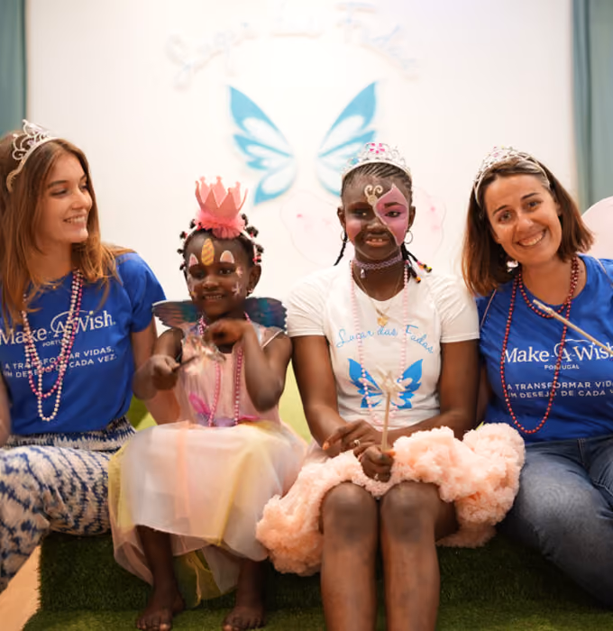Make-A-Wish volunteers with two girls in costume and tiaras