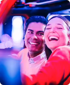 Couple laughing in their car during the drive-through show