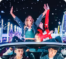 Guest standing up through the sunroof with arms raised above the light displays