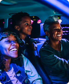 Family of three laughing together in their car at the light show