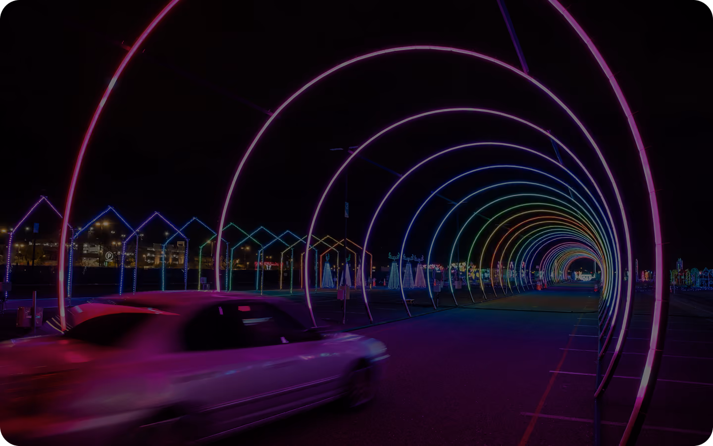 Car driving through a pink and magenta light tunnel