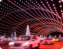 Illuminated Christmas tree and canopy of red lights over the route