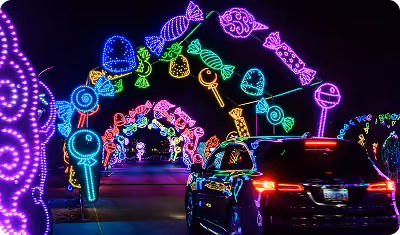 Car driving under an arch of neon candy and lollipops