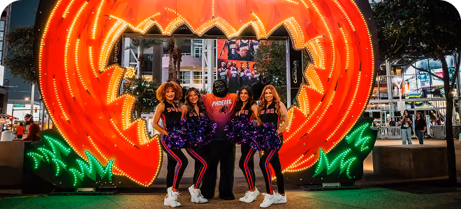 Guests posing in front of a giant illuminated monster mouth display