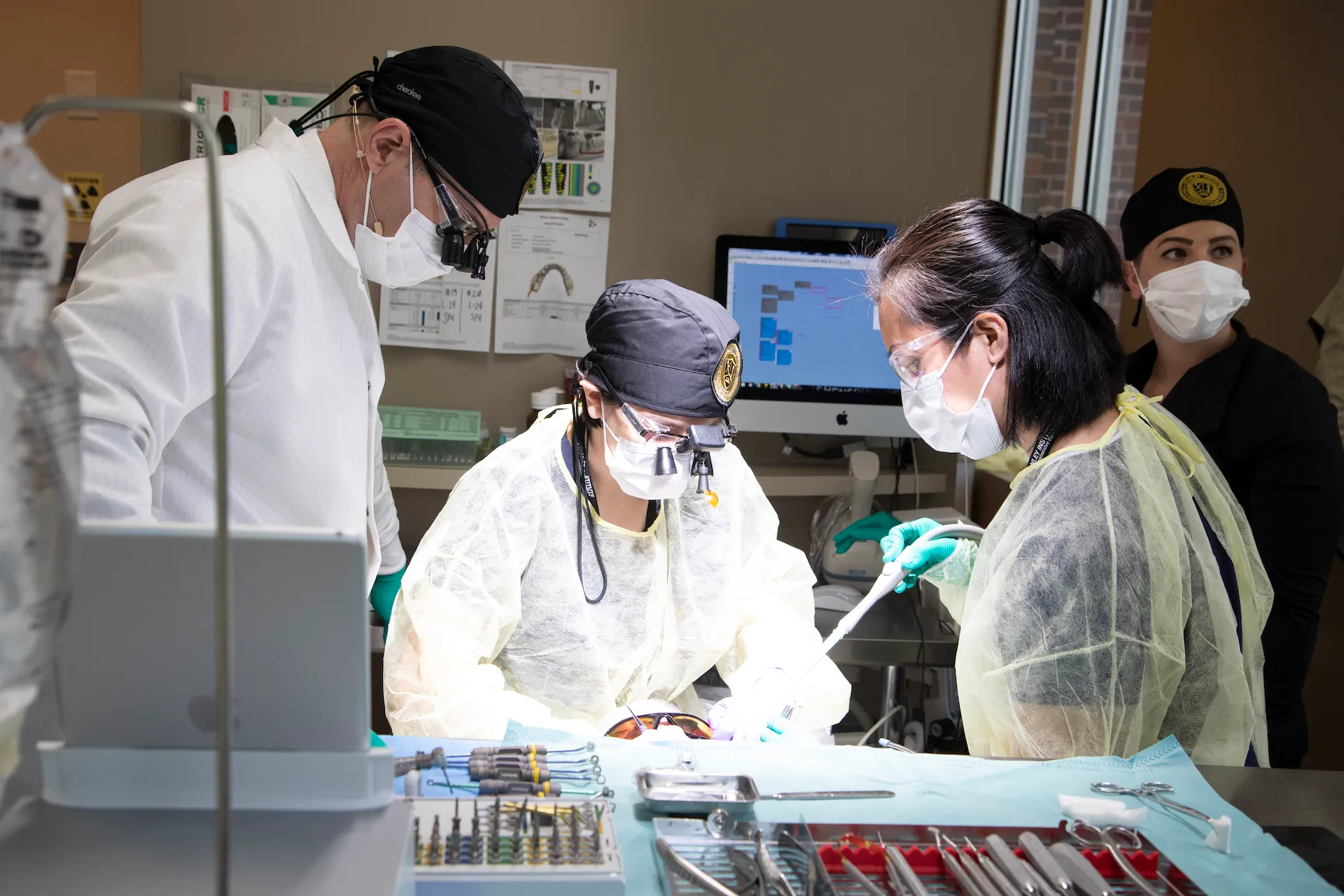 Medical professionals in protective gear working in a dental laboratory