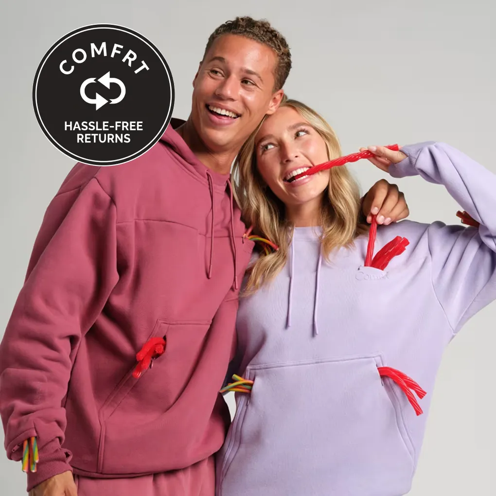 Couple in rose and lavender Snak Hoodies with licorice sticking out of the snack pockets, next to a Comfrt hassle-free returns badge